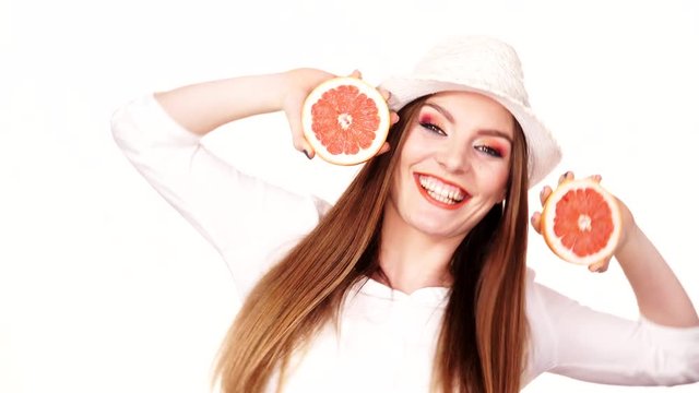 Woman holds two halfs of grapefruit citrus fruit in hands 4K