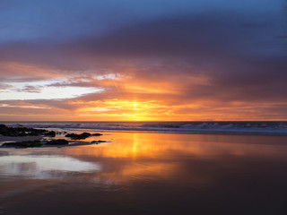 Sunset at the beach with intense glowing orange, yellow, red col