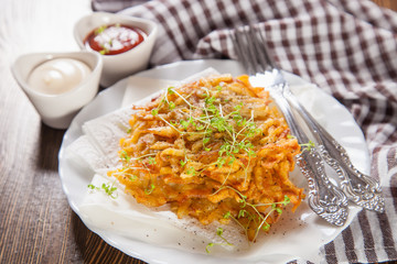 grated potatoes cutlets in a plate on a table, selective focus