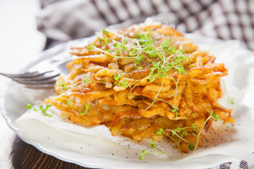 grated potatoes cutlets in a plate on a table, selective focus