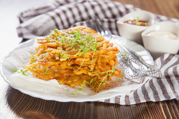 grated potatoes cutlets in a plate on a table, selective focus