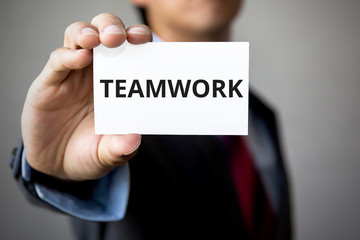 Businessman presenting 'TEAM WORK' word on white card