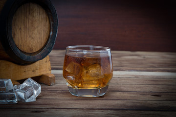Glass of cognac on the vintage wooden barrel