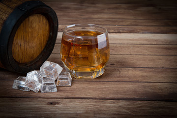 Glass of cognac on the vintage wooden barrel