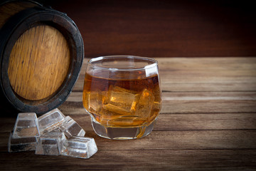 Glass of cognac on the vintage wooden barrel