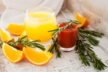 orange and tomato juice on an old shabby background, selective focus