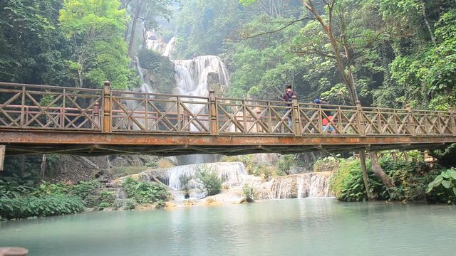 People on bridge looking viewpoint of Kuang Si Falls or Tat Kuang Si Waterfalls on April 8, 2016 in Luang Prabang, Laos