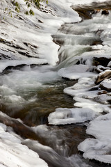 Mountain stream flowing through ice covered rocks in Great Smoky Mountains National Park in the winter near Gatlinburg, Tennessee