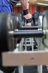 Man in sportswear lifting dumbbell at the gym