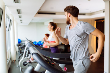 Fototapeta na wymiar People running on treadmill in gym