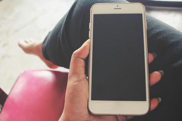 Woman using smart phone on sofa at home