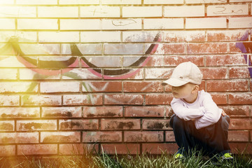 sad boy near brick wall