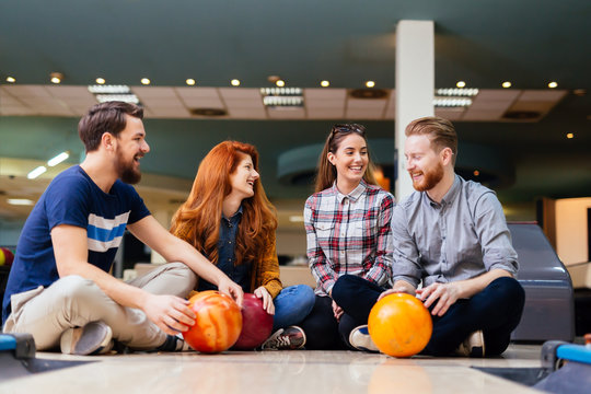 Cheerful friends bowling together