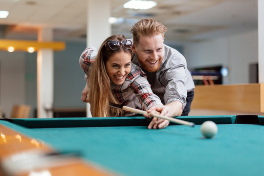 Couple flirting while playing snooker