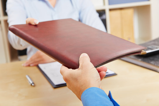 H&auml;nde geben Bewerbungsmappe an Personaler