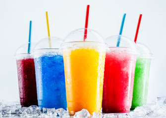 Colorful Frozen Fruit Slush Drinks in Plastic Cups - obrazy, fototapety, plakaty