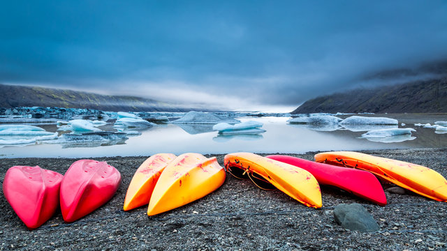 Kayaks on the shore of lake with the glacier, Iceland
