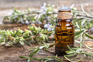 Essential oil made from rosemary on rustic table