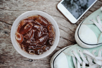 Cola with smart phone and sneakers