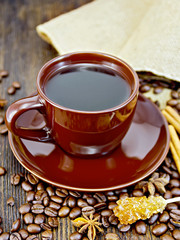 Coffee in brown cup with sugar and bag on dark board