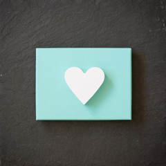 White heart on a turquoise color box on black background. Valentine's day. Present. Gift.