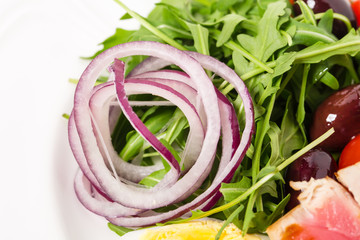 Delicious nicoise salad with arugula and onion.