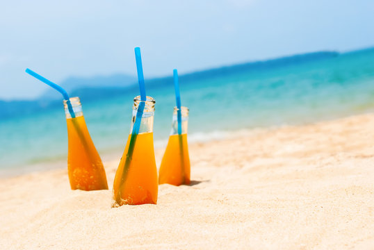 Three Orange Juice Bottles Sea Background Summer