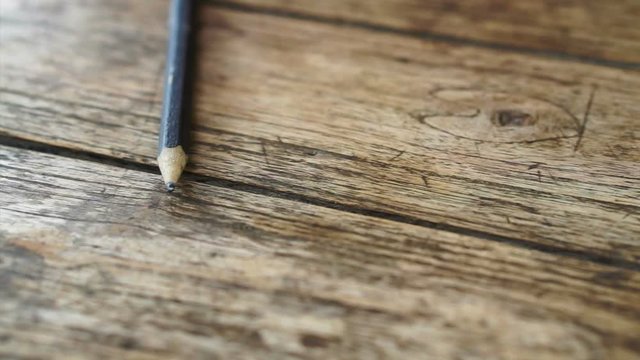 Video of old pencil laying on rustic wood table with copy space