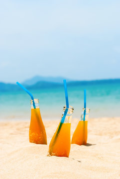 Orange Juice Bottles Straws Beach Sea Background