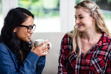 Close-up of young female friends drinking coffee