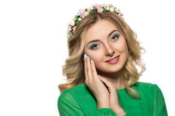 portrait of a beautiful blonde woman in a green dress that looks into the camera and folded her hands near the face