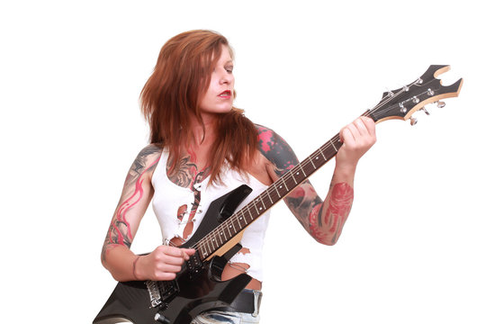 Attractive redhead punk girl with tattoos playing electrical guitar