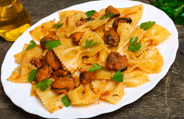 pasta with mussels and parsley on a wooden background