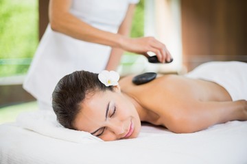 Fototapeta na wymiar Young woman receiving stone massage