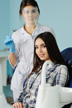 beautiful young girl on the background dentist with medical inst