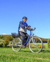 Fototapeta na wymiar Älterer Mann beim Radfahren im Grünen