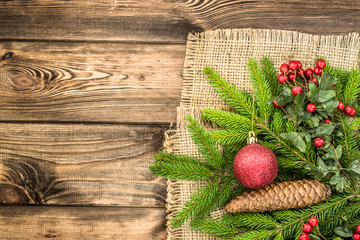 Christmas tree branch of spruce with christmas decoration on wooden table