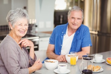 Portrait of happy senior couple having breakfast