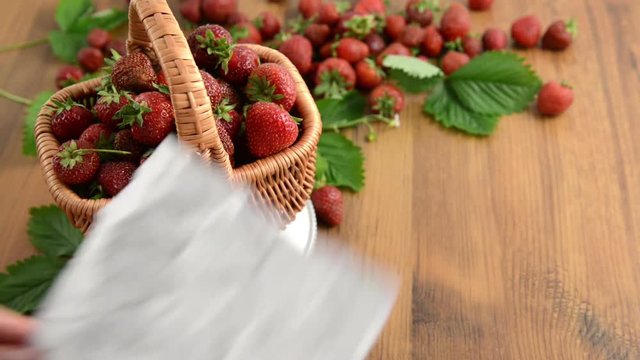 strawberries basket on weight scale with leaf and flower head on wooden table. jam making. laying blank note paper aside.