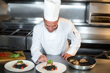 Handsome chef putting finishing touch