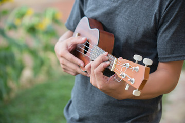 A man playing ukulele in close up view.