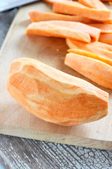 Ripe sweet potatoes on a wooden cutting board
