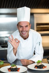 Portrait of chef with food gesturing in a commercial kitchen