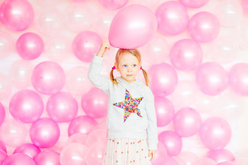 Fototapeta na wymiar little girl playing with pink balloons