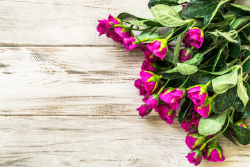 Fototapeta na wymiar Pink roses flowers arranged on wood background.