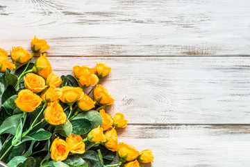 Yellow roses flowers arranged on wood background