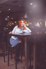 Businesswoman drinking coffee / tea and in a coffee shop.