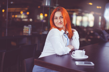 Businesswoman drinking coffee / tea and in a coffee shop.