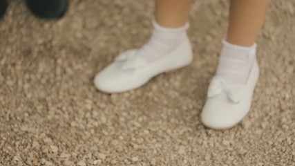 Little girl dancing in white shoes.