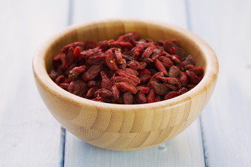 berries goji in bowl on wooden background